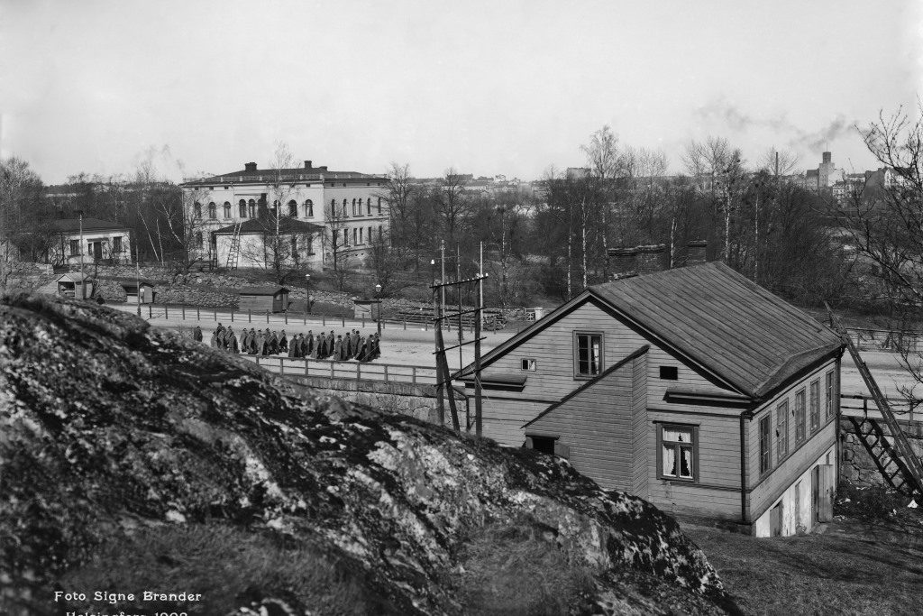 Hakasalmen huvila Turuntien varrella. Tiellä marssii sotilaiden joukko.