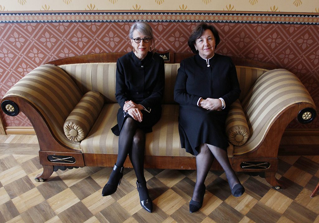 Kaksi naista istuu vierekkäin sohvalla.