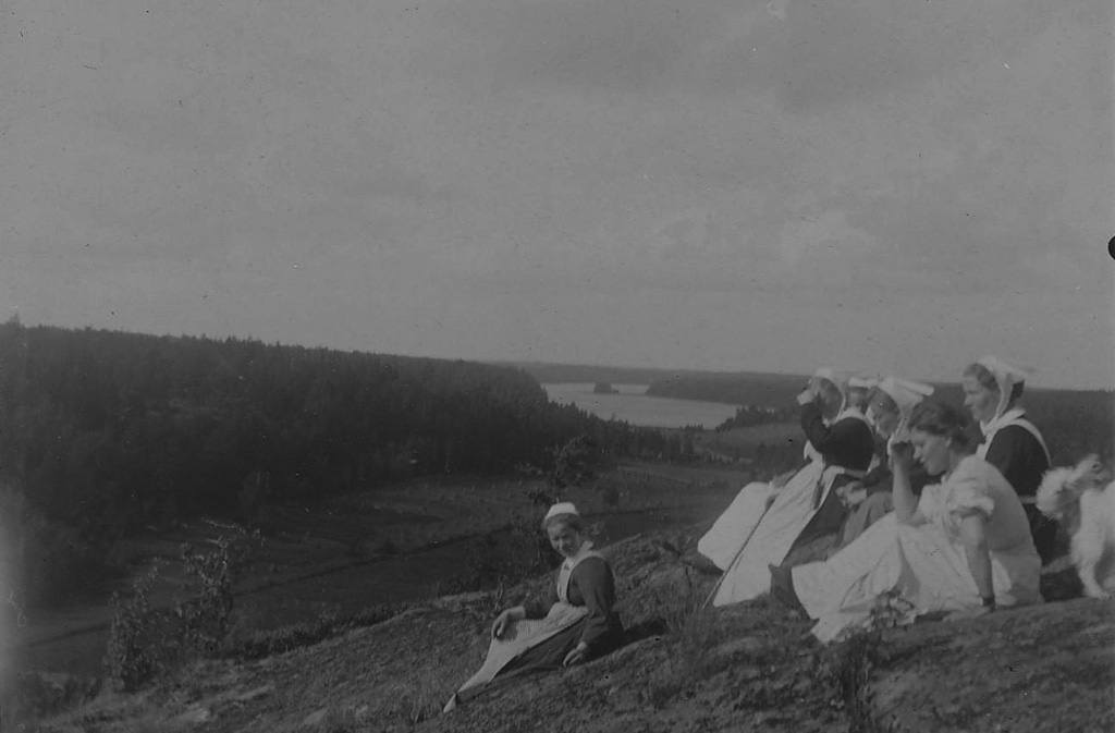 Naisia istuu korkealla vuorella, lomanviettoa Kirkkonummella 1900-luvun alussa.
