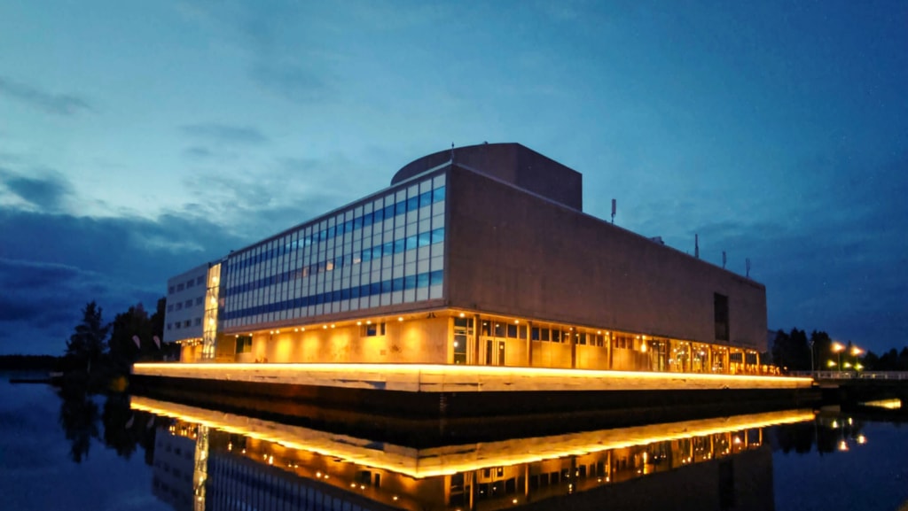 Oulun veden äärellä oleva teatterirakennus. Sen alaosa on valaistu.