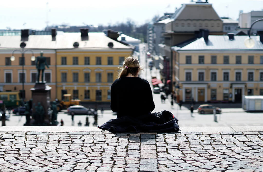 Tyttö, joka istuu Helsingin tuomiokirkon portailla