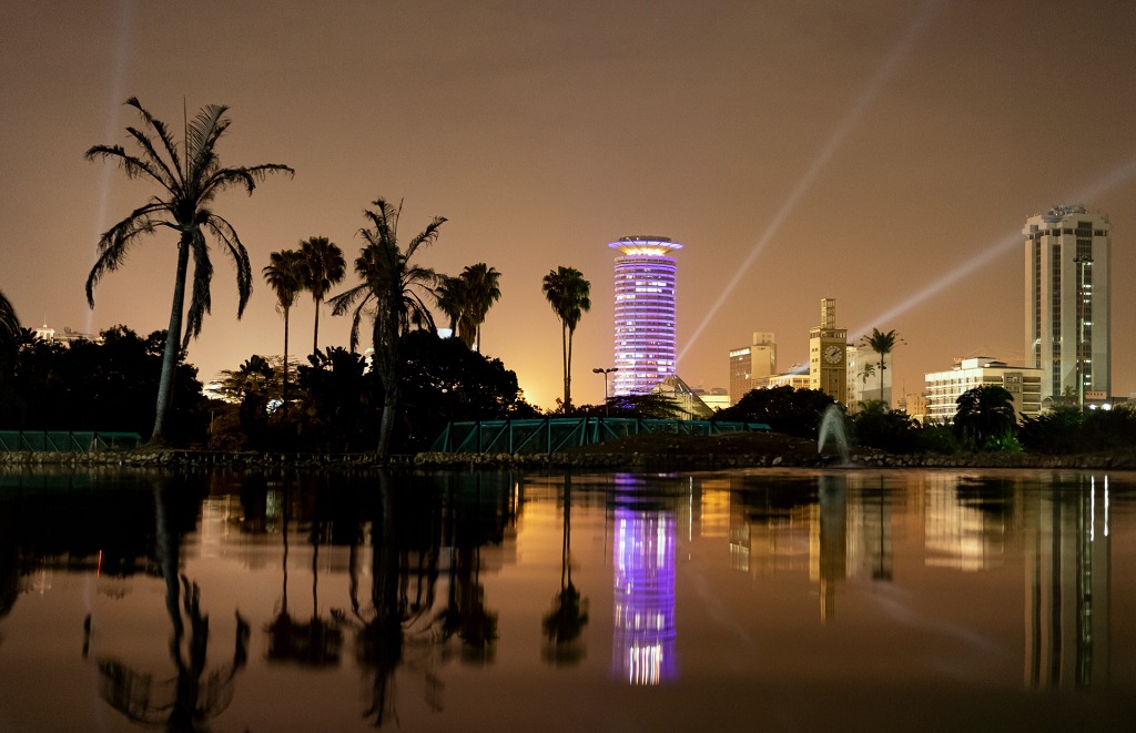 Nairobin pilvenpiirtäjien ja palmujen silhuetit heijastuvat veteen.