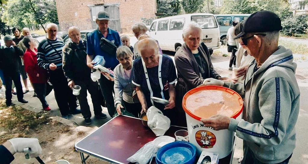 Vanhukset jonottavat vapaaehtoisten jakamaa lämmintä ruokaa Ukrainassa.