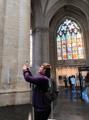 Nuori mies kuvaa yksityiskohtaa kirkossa Brysselissä.
