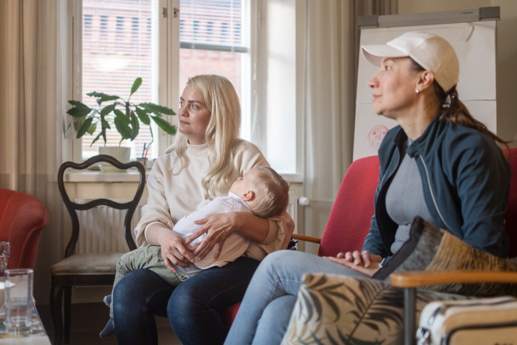 Kaksi naista istuu sohvalla.