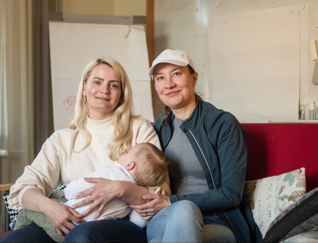 Kaksi naista istuu sohvalla ja katsoo kameraan. Ukrainalaiset naiset saavat tukea Diakonissalaitokselta.