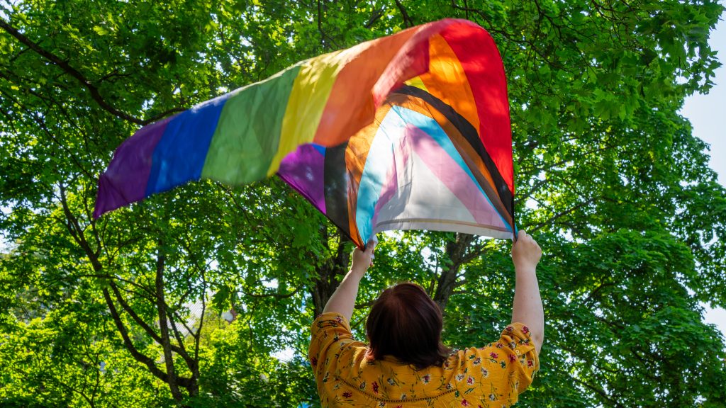 Nainen heiluttaa Pride-lippua.