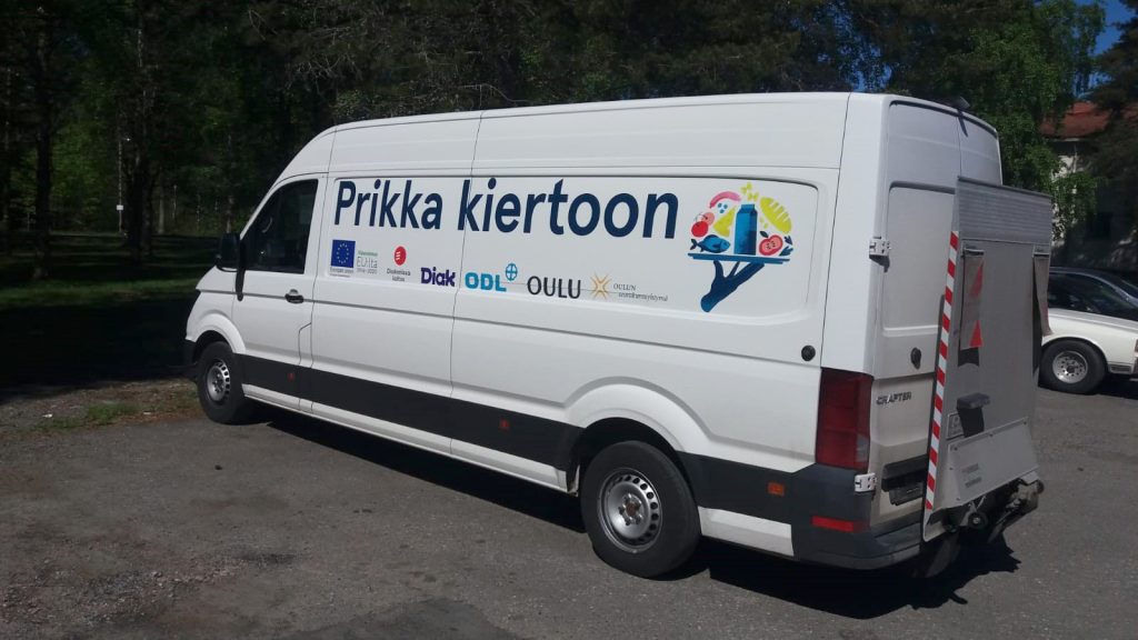 Pakettiauto, jossa lukee Prikka kiertoon. Sen lastina on hyötyruoka.