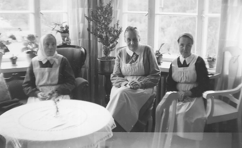 Kolme naista istuu vierekkäin.