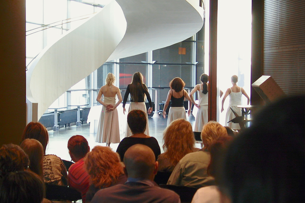 Naisten tanssiryhmä selin yleisöön, joka on kuvassa etualalla.