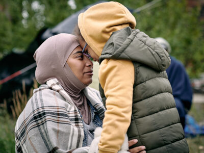 Lähi-idästä kotoisen olevat äiti ja tytär katsovat ja koskettavat otsillaan toisiaan.