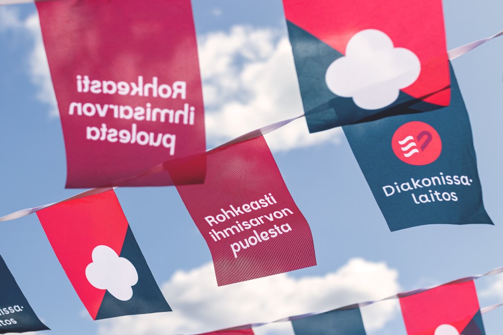 Viirejä, joissa lukee Rohkeasti ihmisarvon puolesta, liehumassa taivasta vasten.