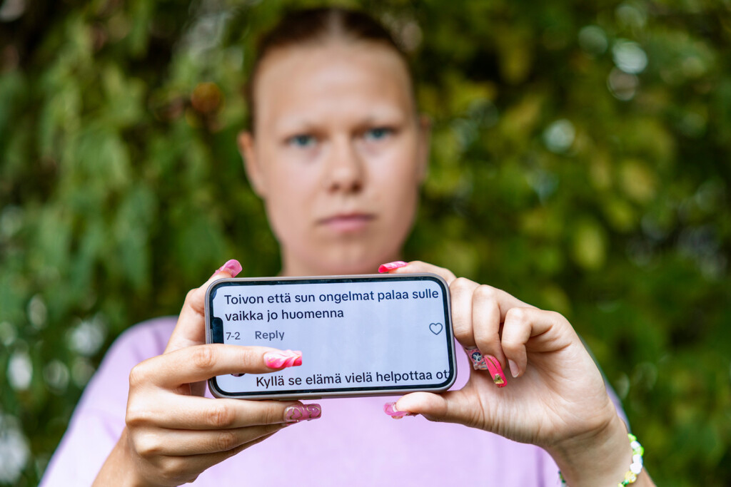 Nuori pitelee kädessään puhelinta, jonka ruudulla teksti: "Toivon että sun ongelmat palaa sulle jo huomenna".