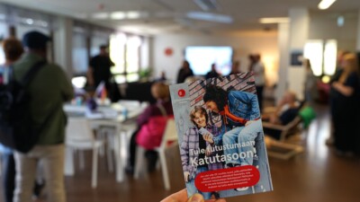 Lähikuva esitteestä, jossa lukee Katutaso. Taustalla ihmisiä.