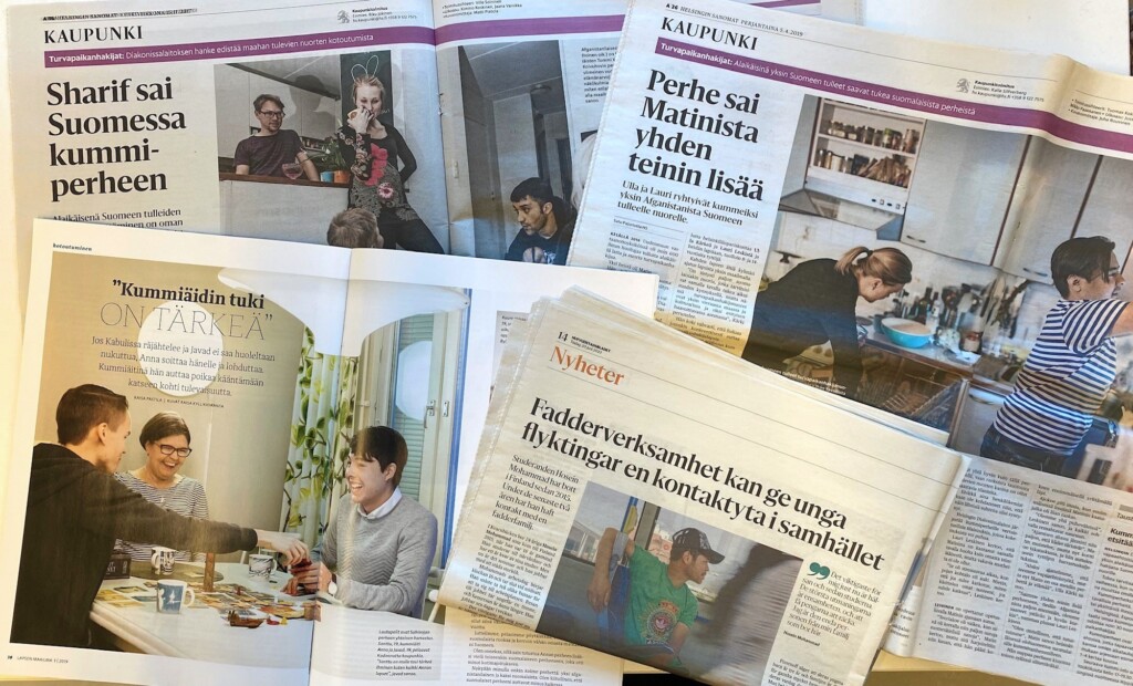 Lehtileikkeitä levitettynä pöytälle.