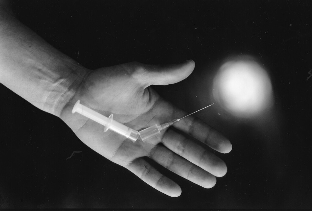 Käsi, joka pitelee rikkoutunutta ruiskua.