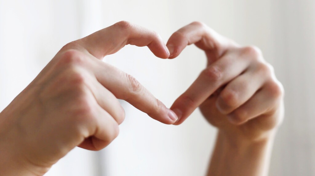 Kädet, jotka muodostavat sormillaan sydämen.